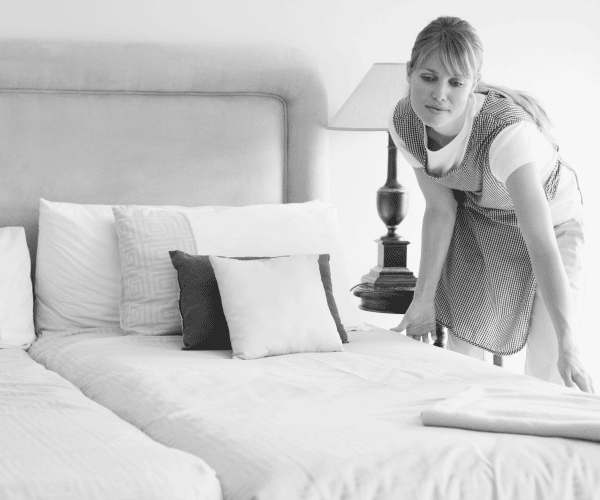 Frau bei der Reinigung eines Hotelzimmers