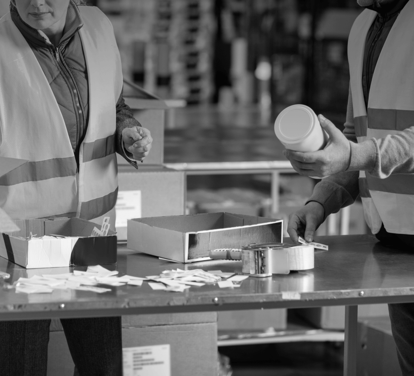 Close-up of two warehouse operatives packing boxes