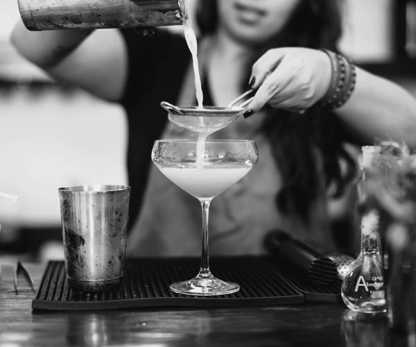 Close-up photo of young woman pouring a cocktail